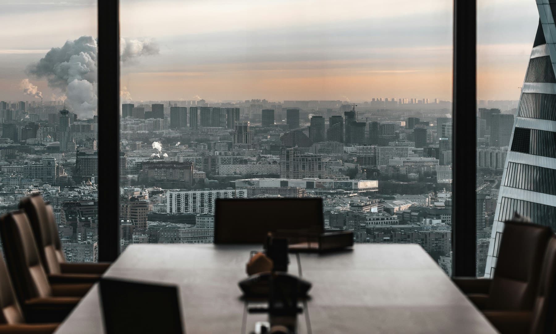 An executive boardroom overlooking a city skyline at dusk
